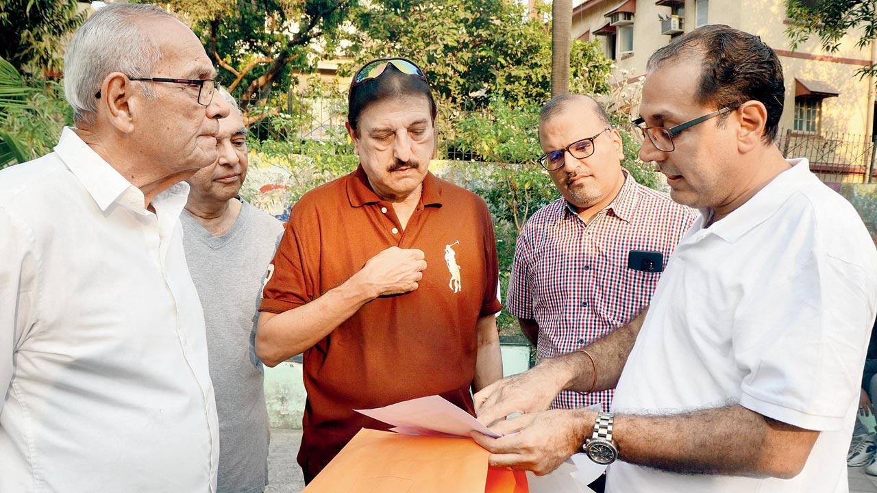 Activist Zoru Bhathena (right, holding papers) speaks to the residents of Tata Blocks, on Wednesday. Pic/Anurag Ahire
