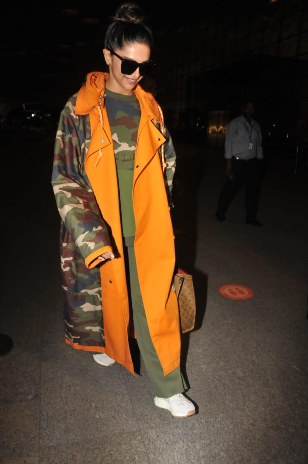 Bollywood actor Deepika Padukone got snapped in the early hours of Tuesday morning at the International Mumbai airport, made a stellar style statement as she arrived donning a chic long and oversized camo-print trench jacket. 