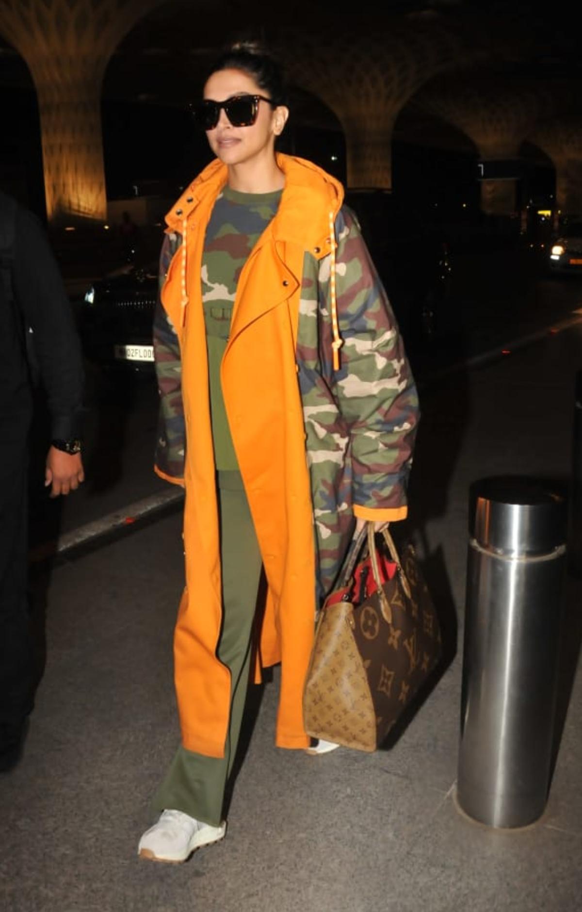 Deepika who is referred to as the queen of airport looks by her fans and the fashion police, looked uber-cool as she paired up her stylish camo-trench jacket with a matching sweatshirt and olive green track pants. 