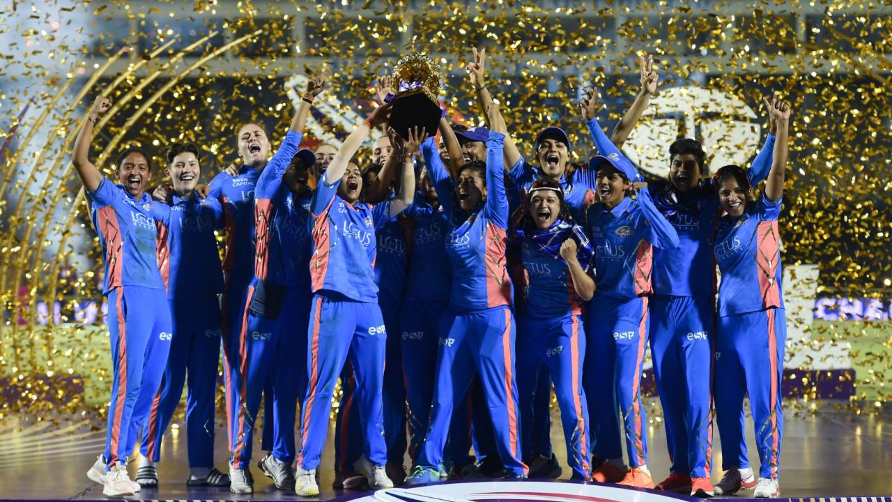 Mumbai Indians' players pose with the trophy after winning the 2023 Women's Premier League (WPL) Twenty20 cricket final match at the Brabourne Stadium in Mumbai.