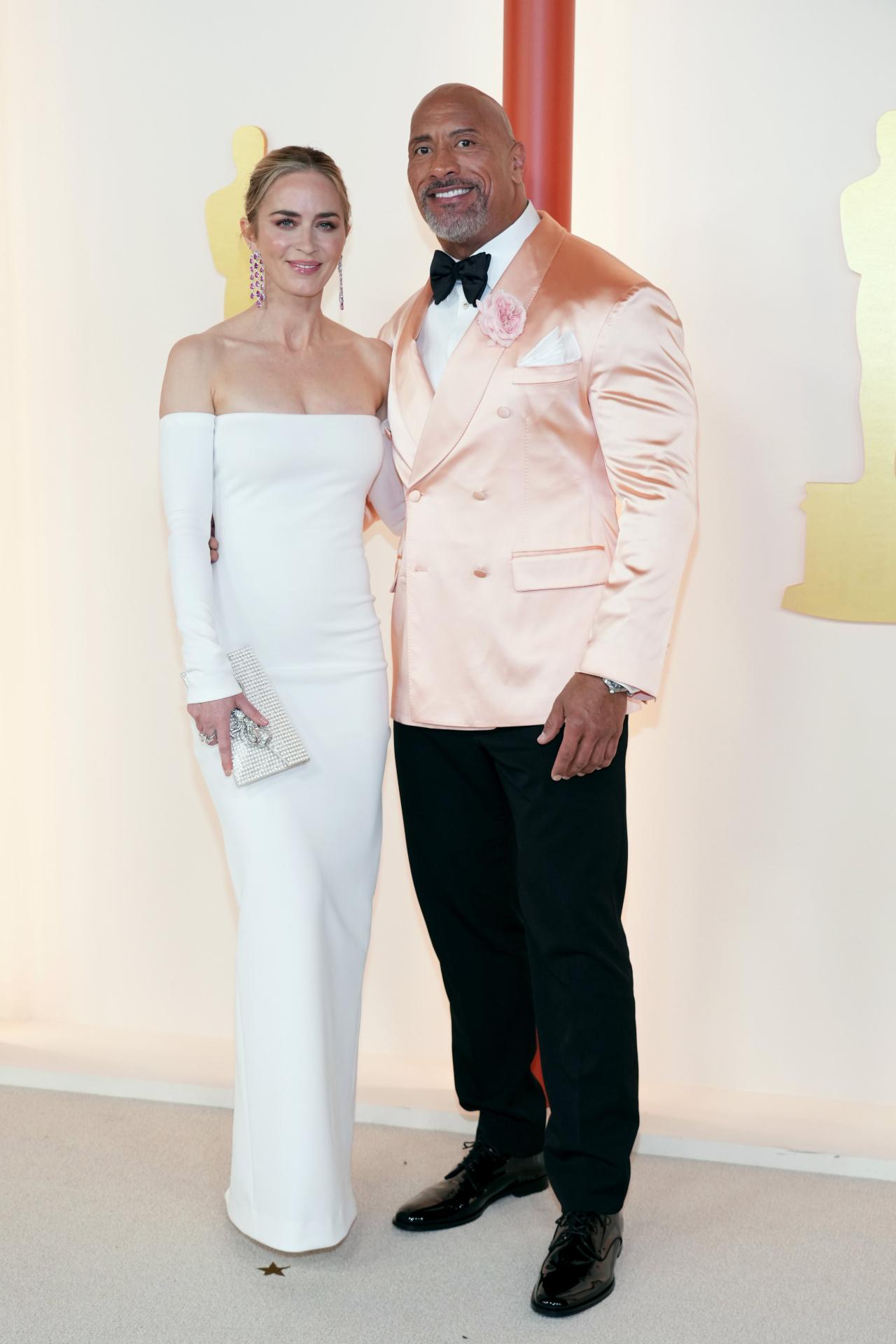 Hollywood star Dwayne Johnson wore a coral jacket at the 95th Annual Academy Awards.He posed with co-presenter Emily Blunt at the red carpet. The actress looked stunning in a white gown