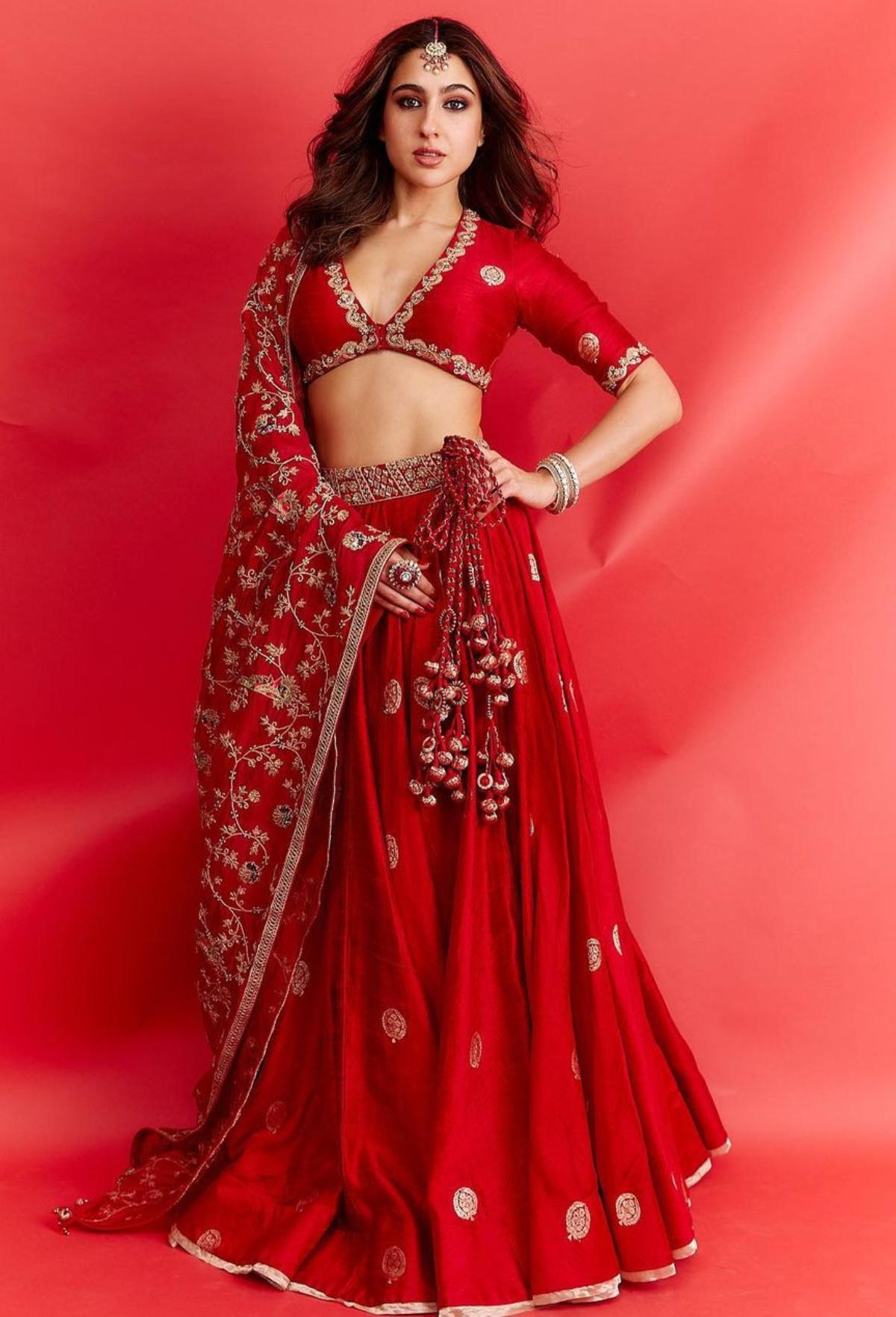 Sara Ali Khan who stole the show donning a ravishing red embroidered lehenga with a plunging v-neck, looks every bit of royalty. The actor who played muse for fashion designer Punit Balana at the recently held Lakme Fashion Week 2023, in the same red lehenga, made netizens go gaga over her effortless elan and unmatched beauty. The enchantress who flaunted her curves in the bespoke red lehenga, looked like a dope millennial bride as she accessorised her extravagant ethnic look with a maang tika and statement bangles. 