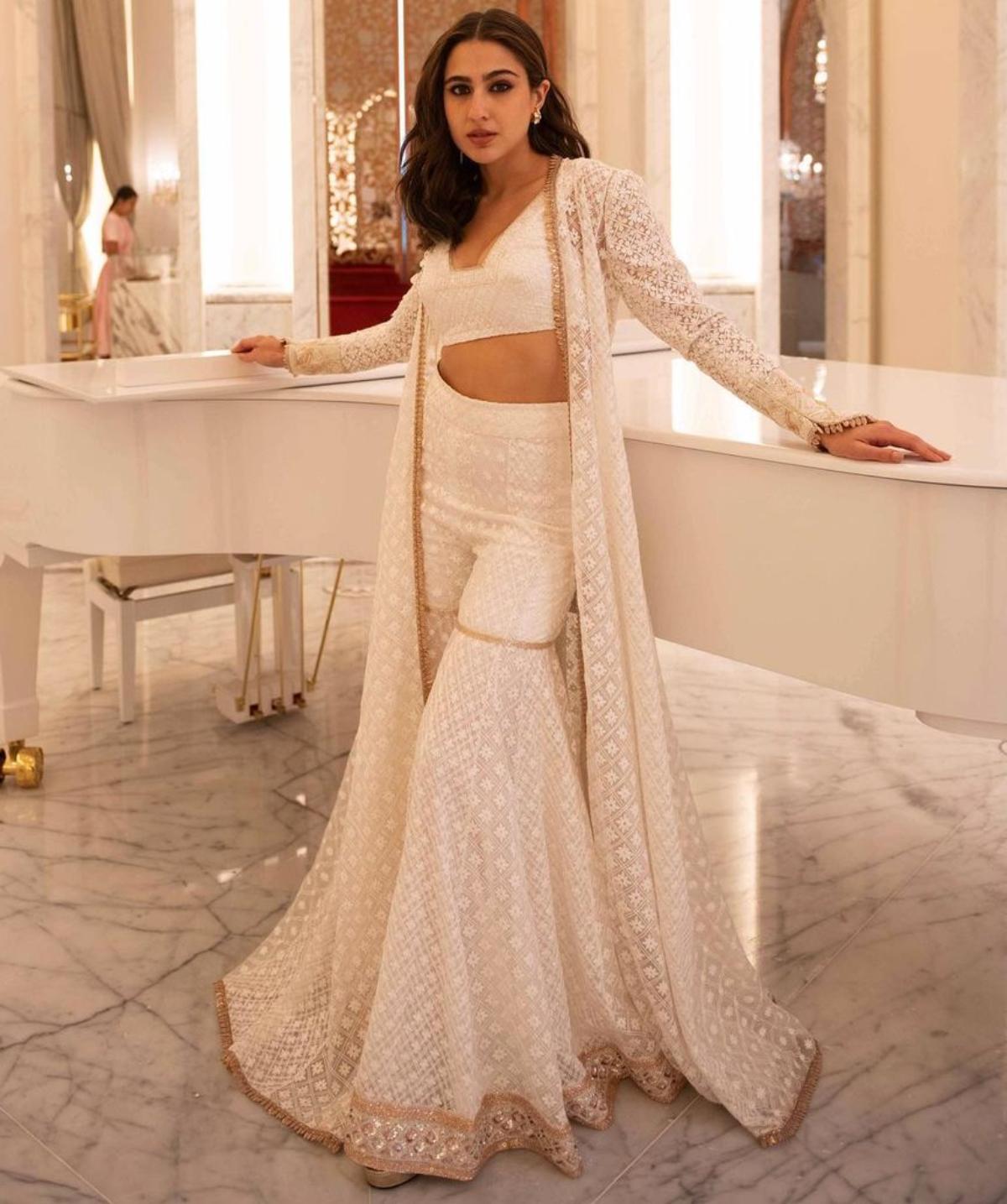 Sara Ali Khan looks like a vision in white as she pulls off a chic and contemporary white chikankari sharara set. The 'Kedarnath' star looks like an absolute angel as she carries off the alluring ethnic attire with all her grace. While the long chikankari jacket adds power to her otherwise ethnic ensemble, the golden borders on her beautiful long jacket and at the hemline of her splendid sharara, gave her intricately embroidered sharara set a tinge of glamour. The young star accessorised her spotless look with nothing but a pair of chunky diamond studs. She beamed with her inner glow as she chose a subtle make-up for her angelic ethnic look. 