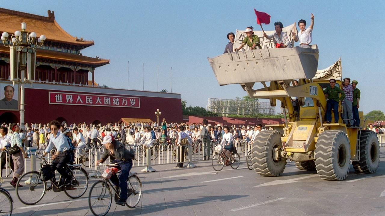 Workers sit in a bulldozer shovel as they shout slogans in front of the Forbidden City in Tiananmen Square in Beijing on May 25, 1989, during a rally to support the student pro-democracy protests.