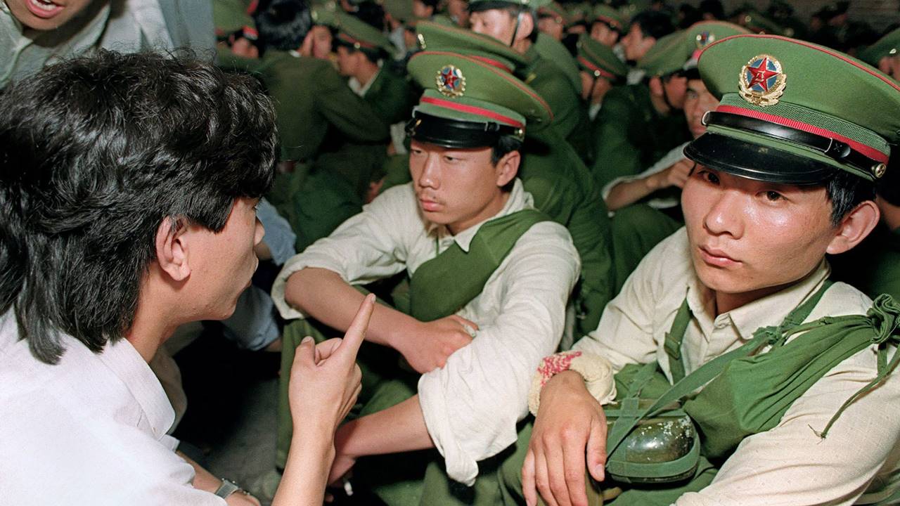  A dissident student (L) asks soldiers to go back home ahead of the army's crackdown on pro-democracy protests in Tiananmen Square in Beijing on June 3, 1989.