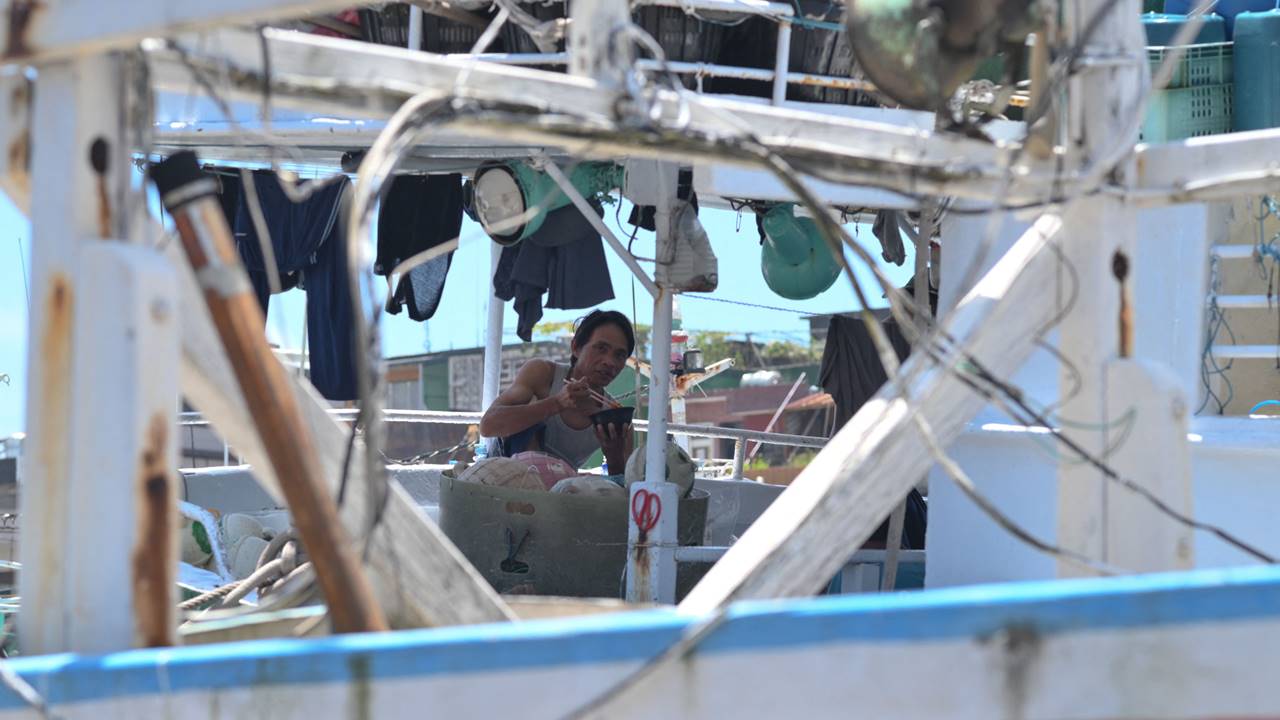A fish worker eats lunch on a Taiwanese fishing boat in the Nanfangao Fishing Harbour in Yilan county as typhoon Mawar approaches.