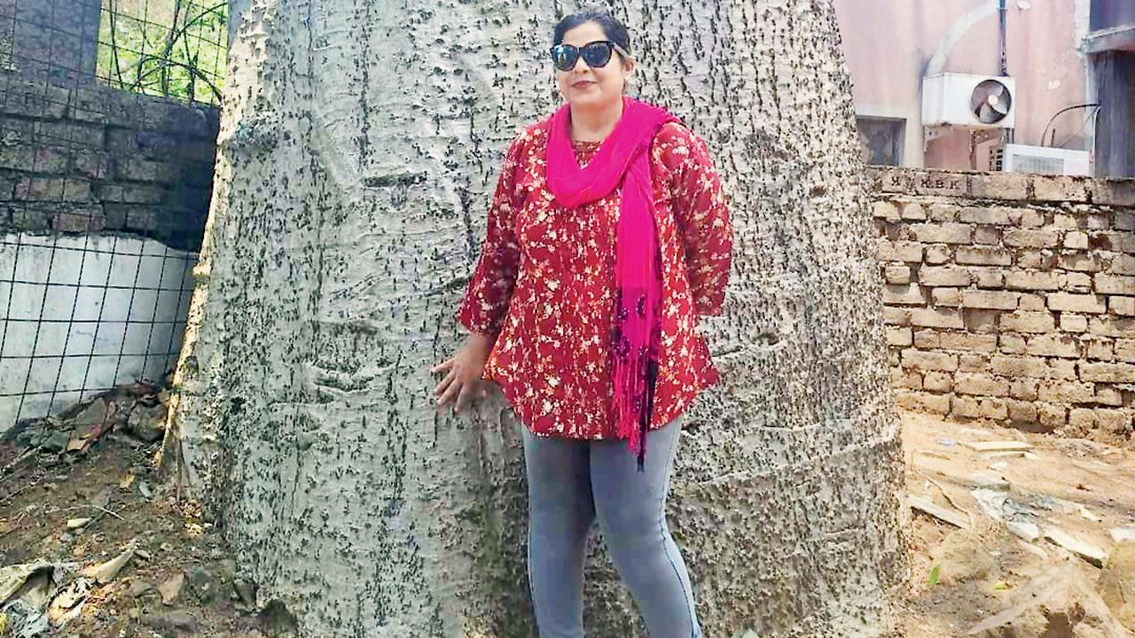 Julie Shinde standing in front of the baobab tree in the Marol church compound