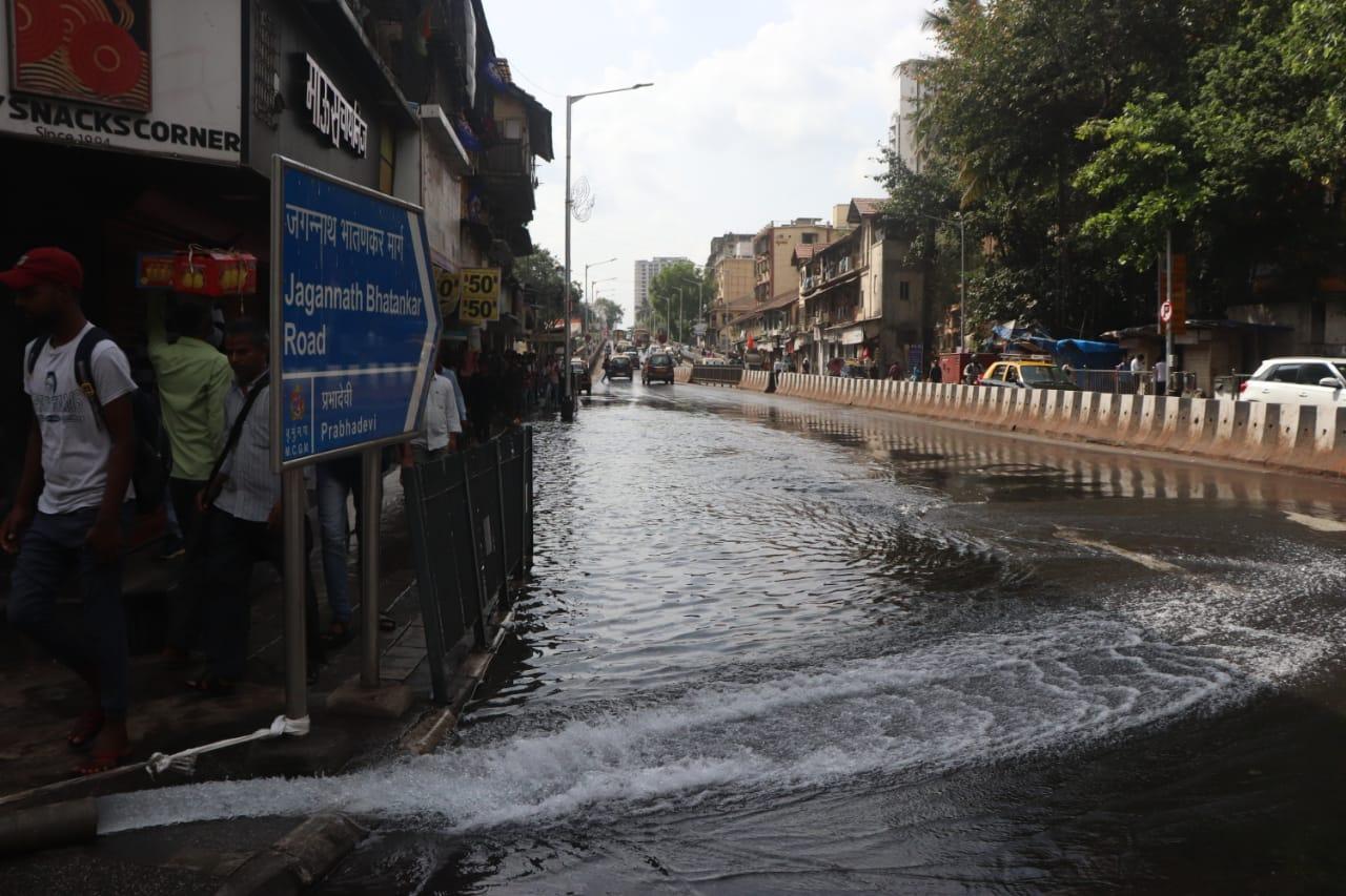 The flooding made it difficult for the commuters to walk on the street located in Prabhadevi