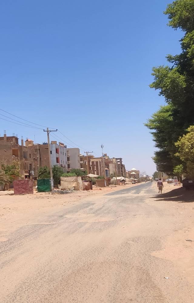 People walk along a deserted street in southern Khartoum, as violence between two rival Sudanese generals continues.