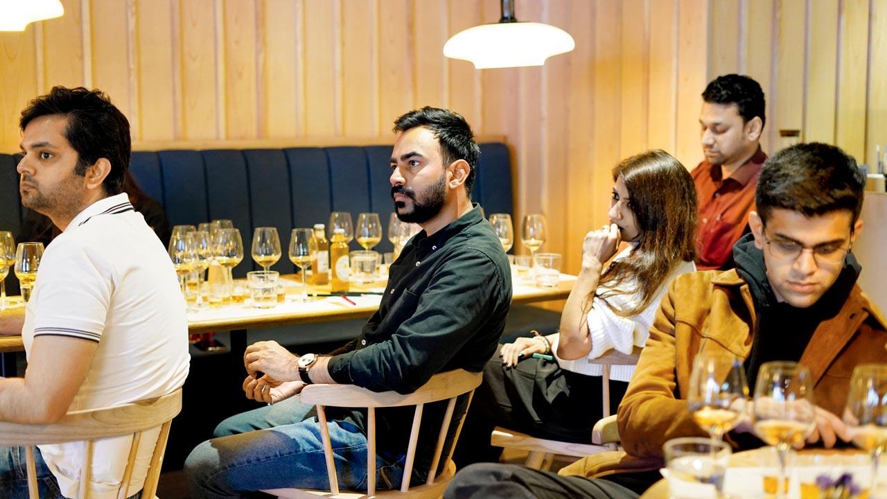Participants at a whiskey-tasting session by Gagan Sharma