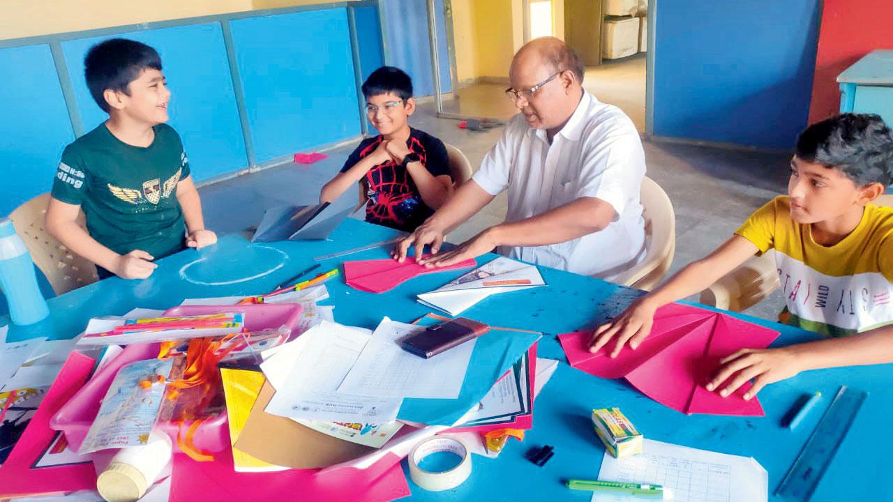 Education officer DS Dharmik teaches children to make glider paper planes