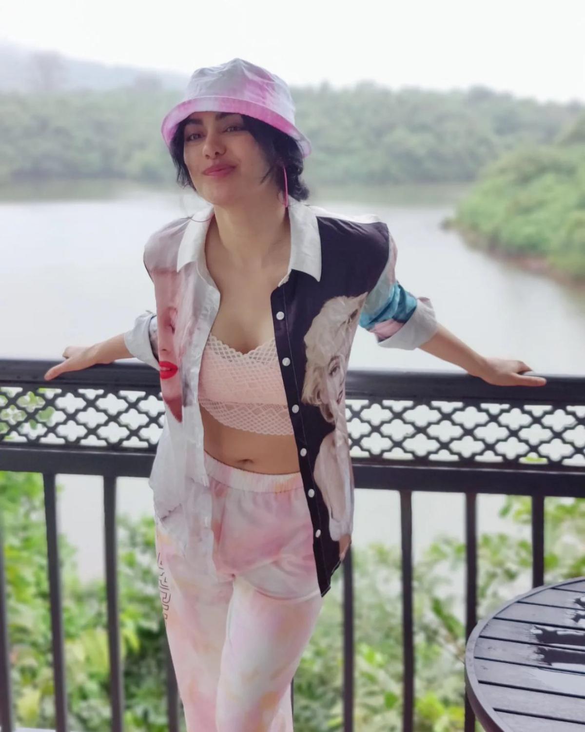 Who says you can't wear a printed shirt with tie-dye joggers and a bralette? Well, if you are Adah Sharma then you surely can! The 'Commando' star, who was last seen in Akshay Kumar-starrer 'Selfie', wears a printed oversize shirt, with photos of Marilyn Monroe splashed all over, with her sexy bralette and tie-dye joggers with her nonchalant grace. To jazz up her otherwise casual ensemble, the actor tops up her quirky, mix-and-match comfy look with a bucket hat. 