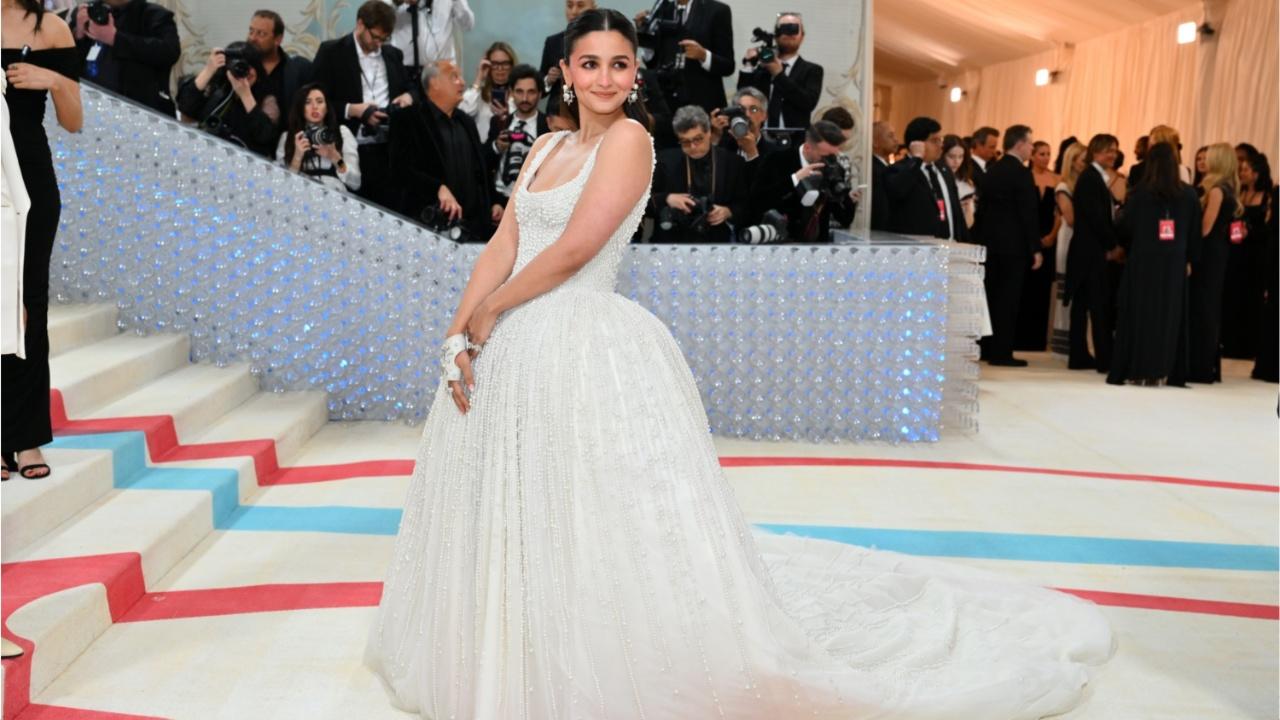 Alia Bhatt debuts at Met Gala 2023 in a dramatic white gown studded with 10,000 pearls. Her outfit is a stunning tribute to Karl Lagerfeld. Photo Courtesy: AFP