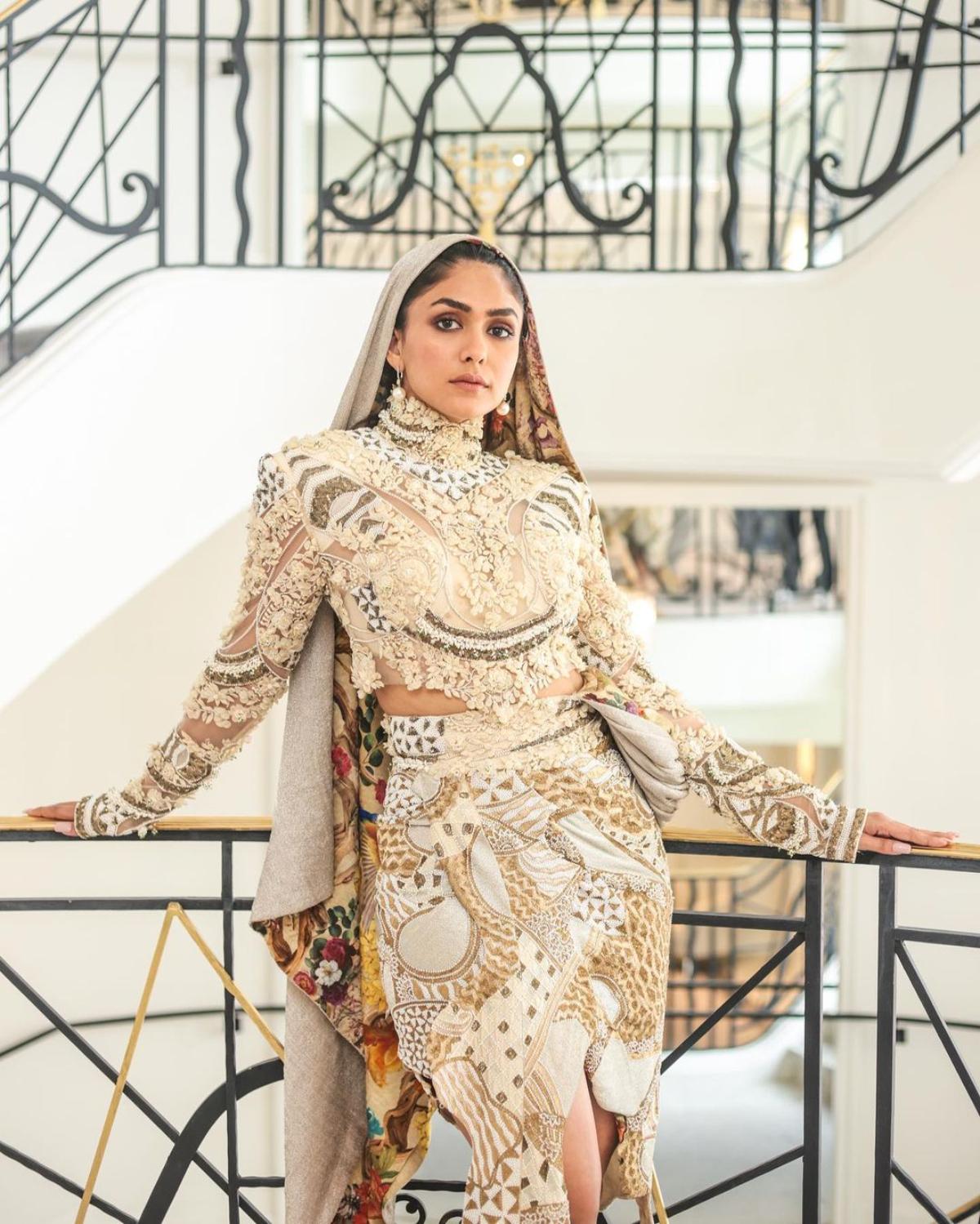 For her second red carpet appearance at Cannes Film Festival, the 'Sita Ramam' star took her fashion game a notch higher as she sported a beige hooded couture short dress and spilled her infectious sass all over as she walked the red carpet in matching high heels like an absolute boss babe. 
