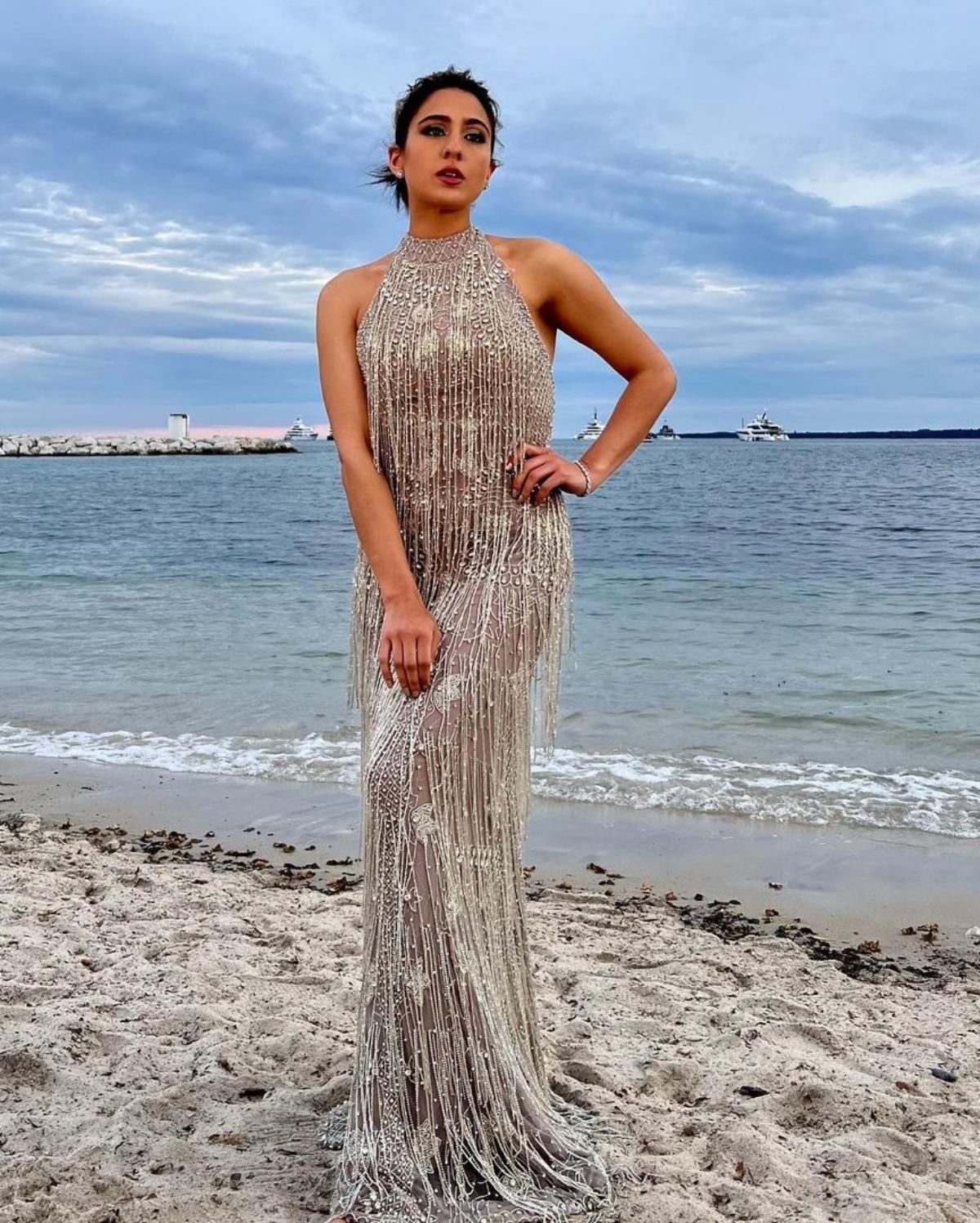 Sara Ali Khan who channelled her inner desi girl by wearing a beautiful beige lehenga by ace designer duo, Abu Jani Sandeep Khosla, on day 1 of the Cannes Film Festival, slipped into a glamorous fringe gown as she attended the Vanity Fair annual Cannes Film Festival Party. The gorgeous diva who loves being a goofball on social media, dropped a string of breathtaking photos where she can be seen standing at a beach, striking a pose in the shimmery outfit. While sharing the photos of her final look, Sara wrote, 