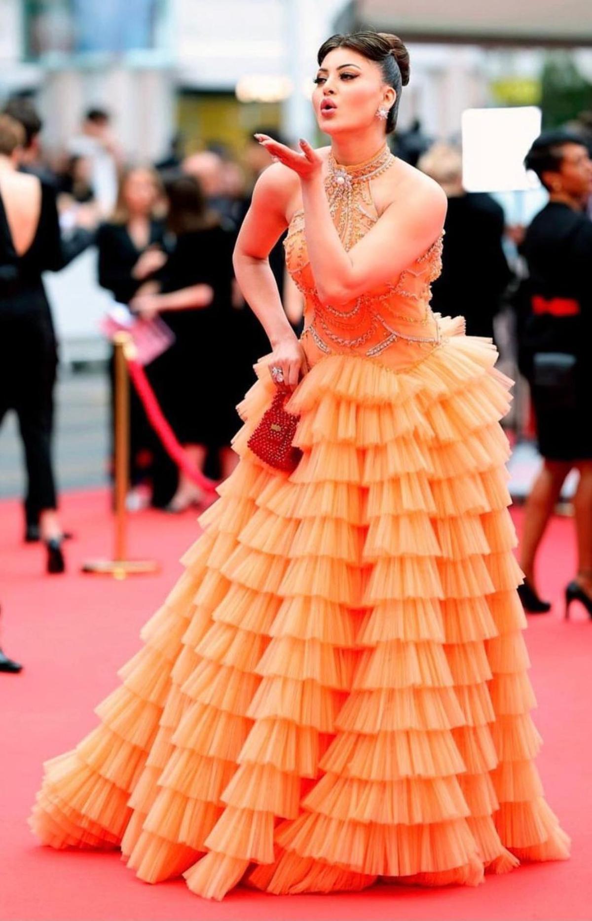 Urvashi Rautela who made headlines for wearing a crocodile necklace with her pink tulle gown on day one at the Cannes Film Festival, stepped out in a frilly orange gown with a halter neck and crystal detailings on the second day.  She carried a small red beaded bag to compliment her eye-popping attire. For makeup, Urvashi opted for a soft glam look.