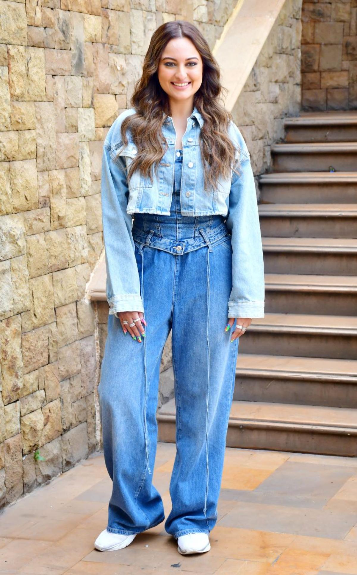 Sonakshi Sinha who will be headlining the gritty and gripping crime-drama series, 'Dahaad', looks effortlessly edgy as she pulls off an all-denim ensemble with grace and elan. Donning a denim corset top along with loosely fit boyfriend jeans, the 'Dabaang' star shows us how to rightly dress up the street way as she tops off her all-denim outfit with a chic light blue denim jacket. While Sona wore white sneakers to look more comfy and chic, the actor painted her nails in vibrant neon colours to add some drama in her otherwise co-ordinated look. 