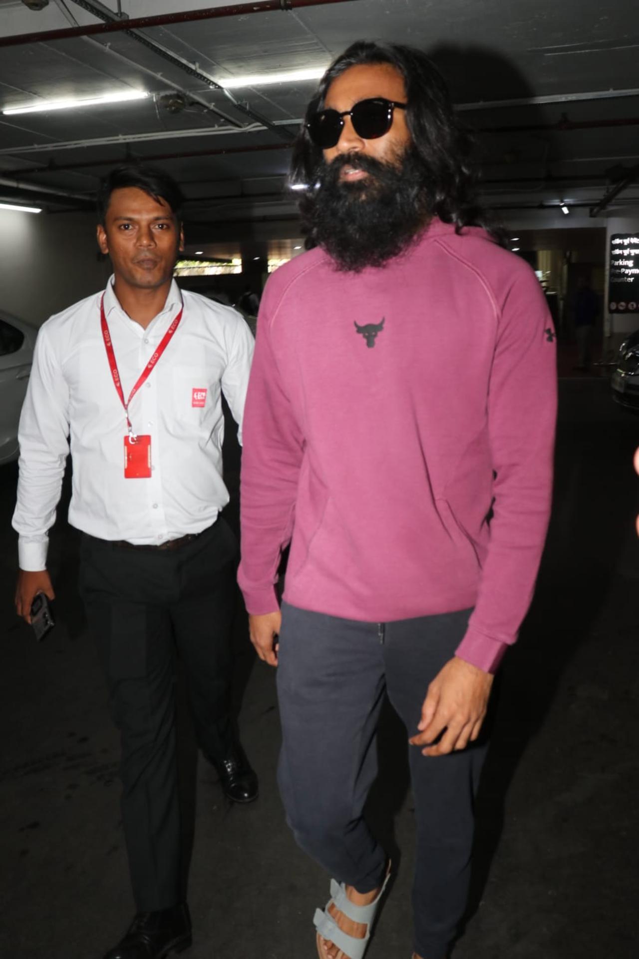 Dhanush was seen sporting a full grown beard and long hair. He let his hair fly as he walked out of the airport surrounded by a sea of paparazzi