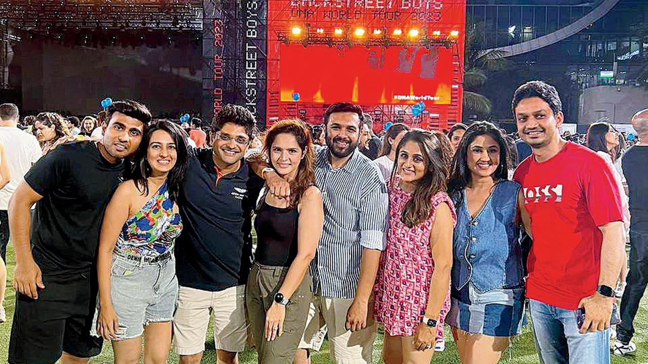 Kinni Jhaveri (in black) and her friends with the Backstreet Boys stage behind them