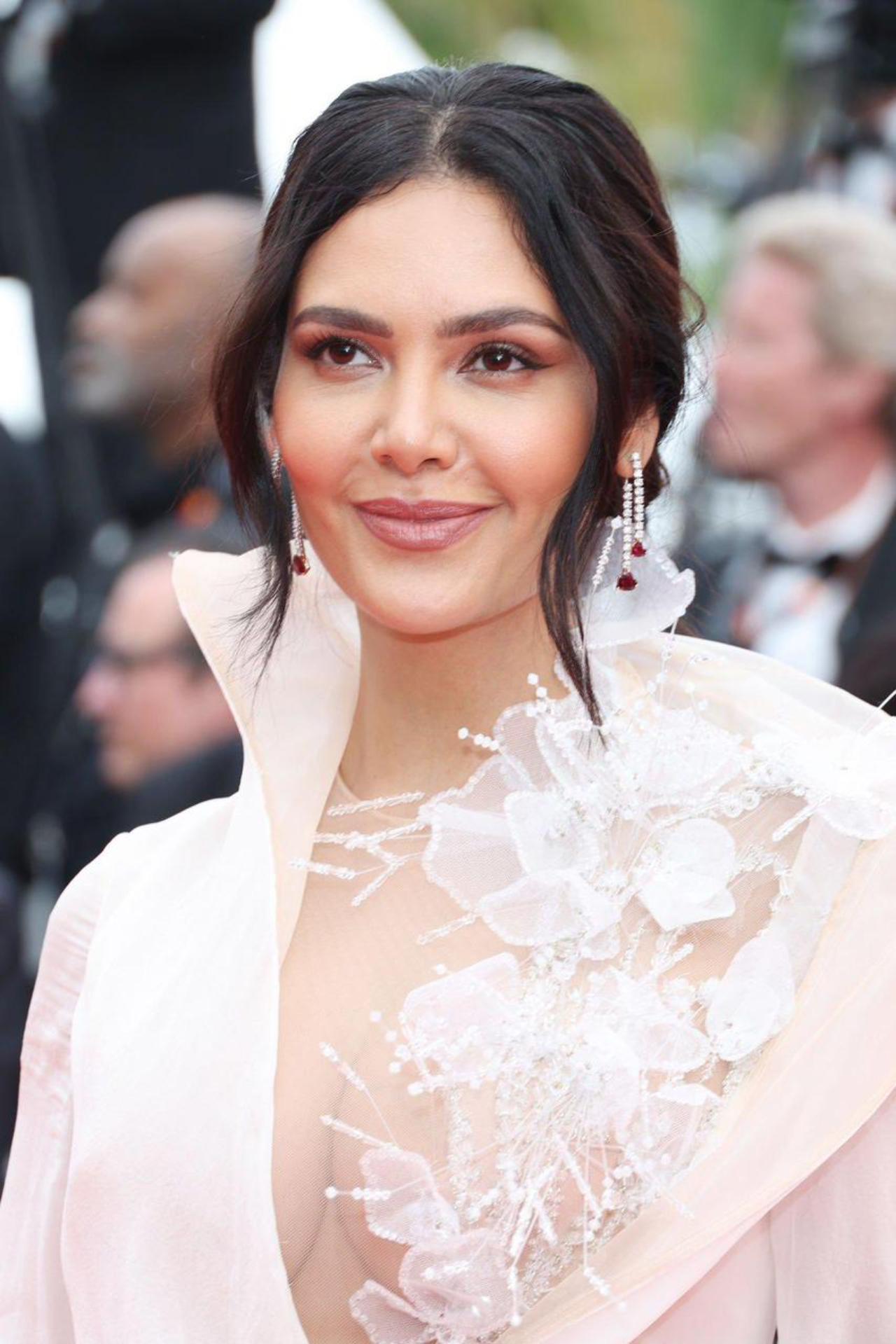 Esha Gupta made a notable entrance at the Cannes Film Festival 2023, gracing the red carpet in a stunning white Nicholas Jebran gown. Her elegant ensemble featured a beautiful floral design on the front and a high slit, captivating everyone with her sophisticated appearance.