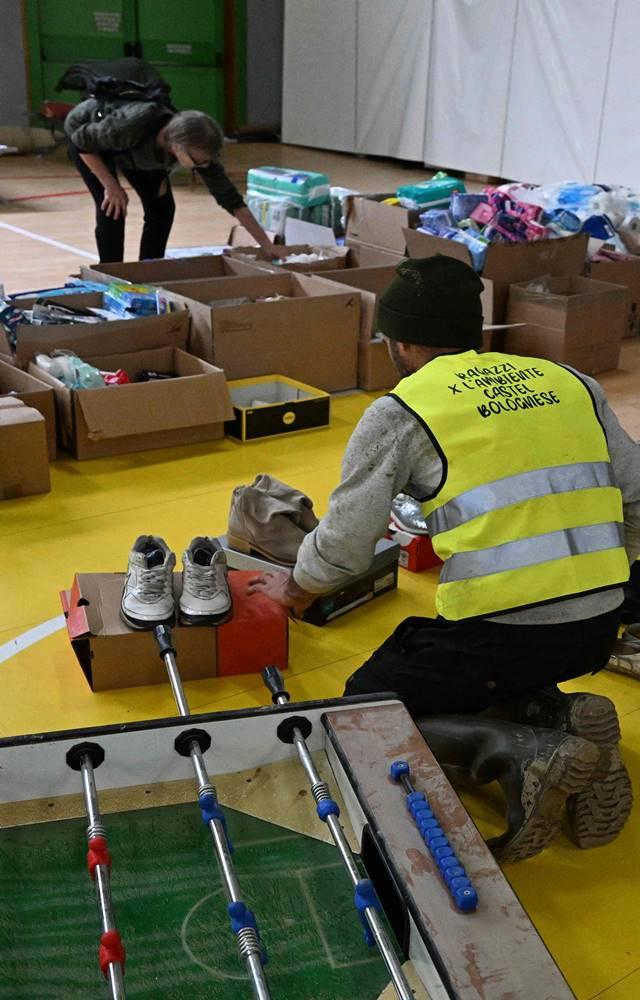 A volunteer (C) organising donated clothes and shoes for residents from the region, who where evacuated from their homes.