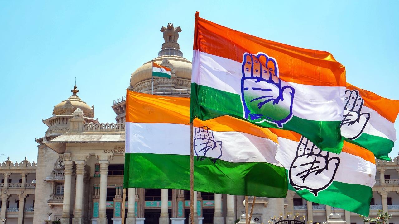Congress workers holding the party flag celebrate the party's win in Karnataka Assembly elections, outside Vidhana Soudha in Bengaluru, Sunday, May 14, 2023. PTI Photo