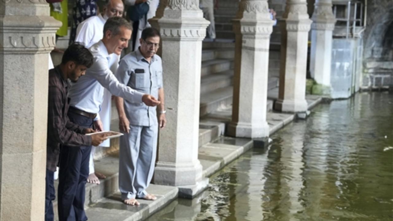 United States Ambassador to India Eric Garcetti feeds the fish at the Jama Masjid