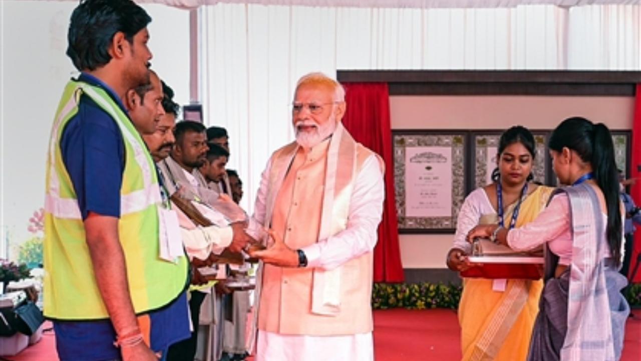 Prime Minister Narendra Modi felicitates workers involved in the construction of the new Parliament building
