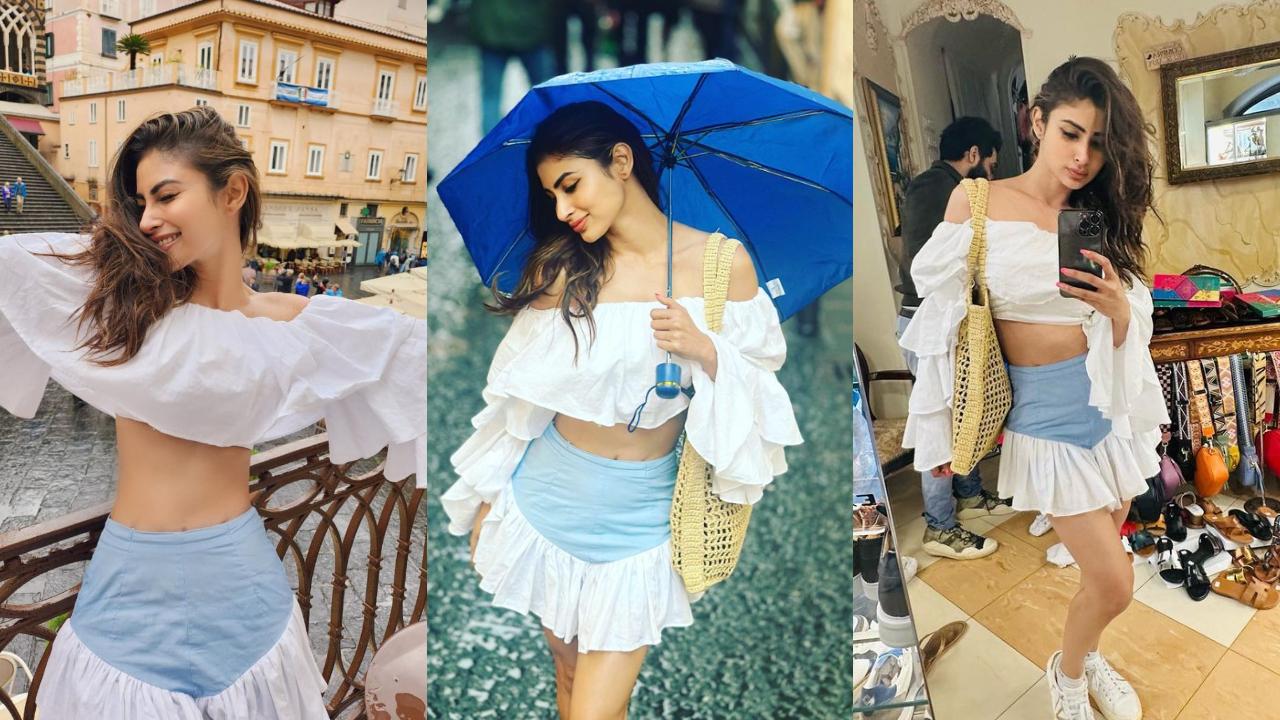 Actress enjoying the weather, clicking mirror selfies, and posing with the umbrella in the middle of the street in Italy.