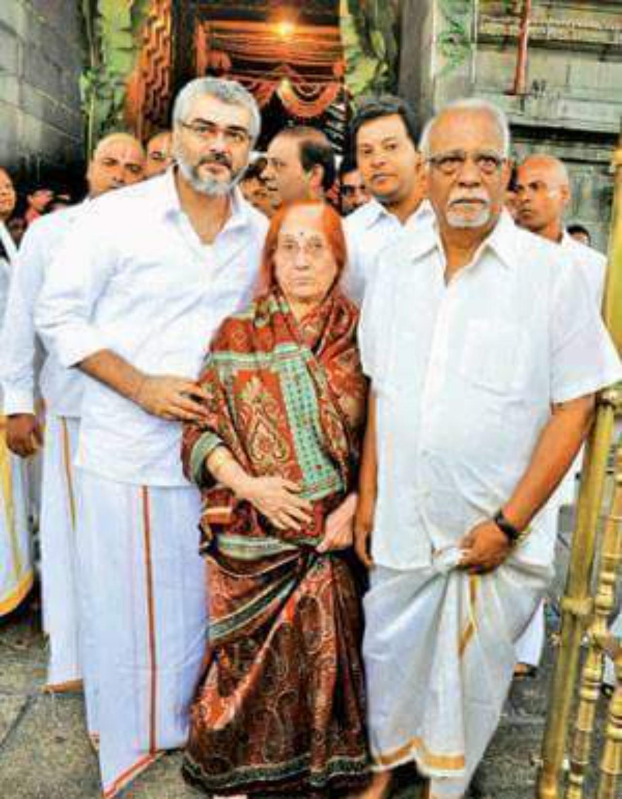 Ajith poses with his parents at a temple