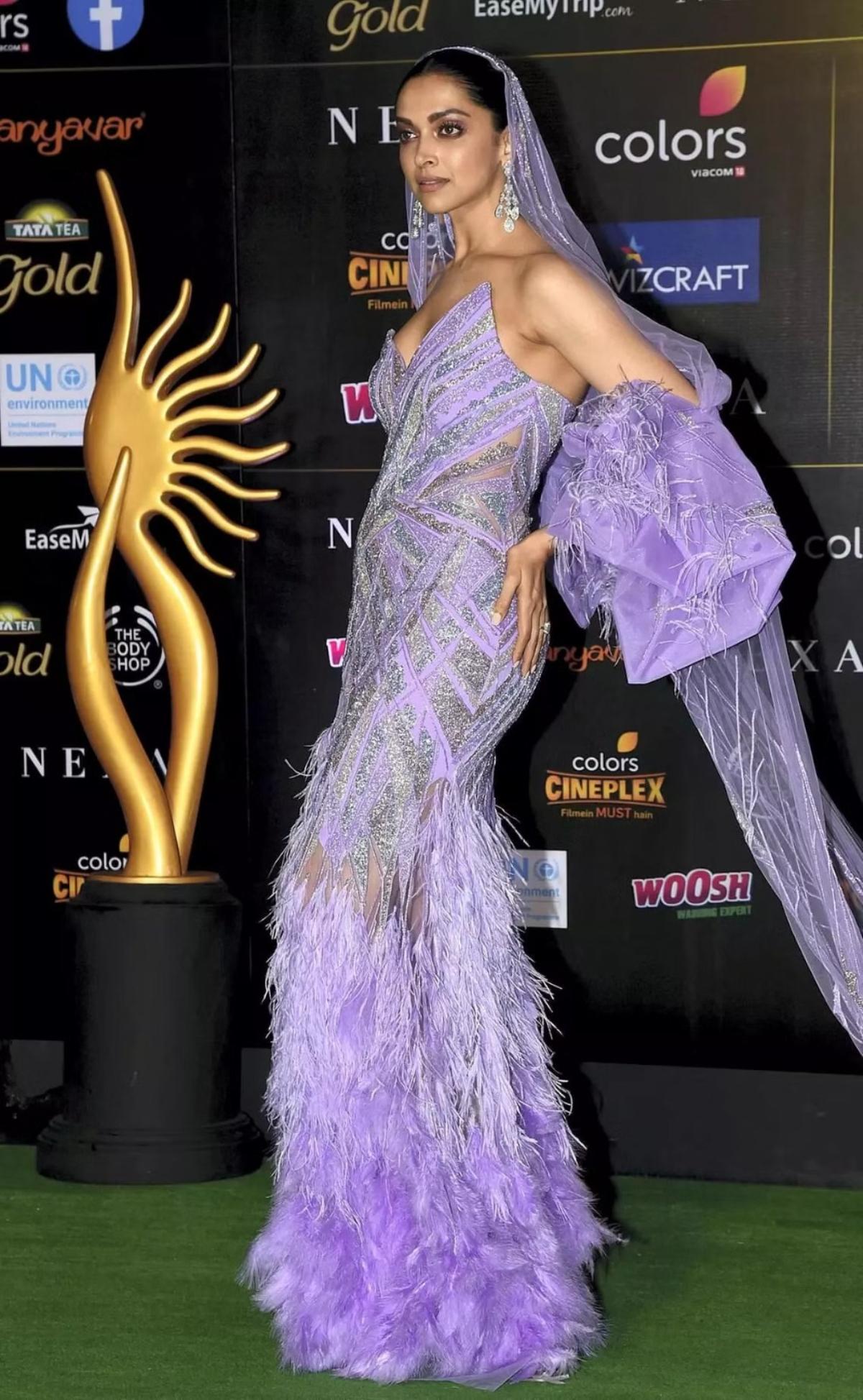 Deepika Padukone, the style queen of Bollywood, left everyone awestruck with her enchanting purple gown. Designed for an award show, the gown featured exquisite frills at the bottom, while a captivating cape draped over her head with a trail.