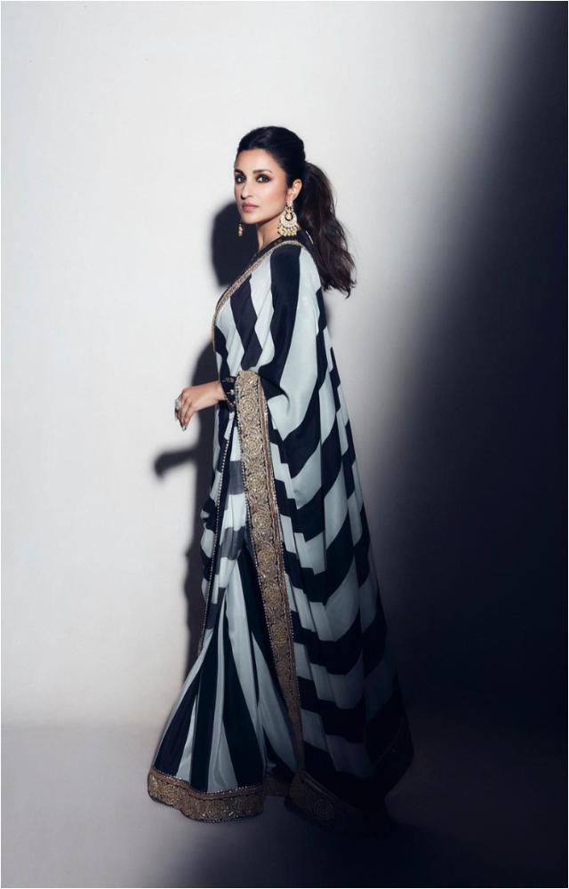 Parineeti Chopra wore a white and black striped saree with gold pati borders and floral motifs. Full-sleeved blouse, giving it a desi touch.