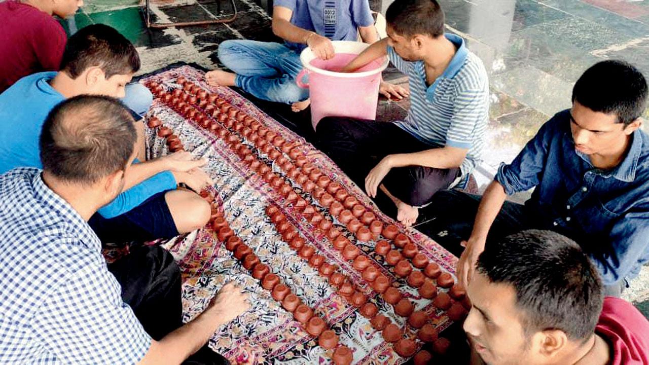 Differently-abled individuals make diyas at the foundation