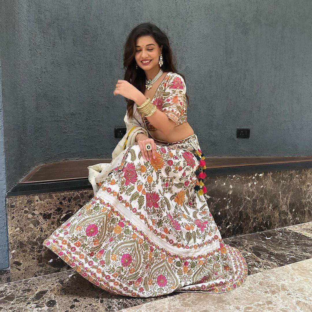 For the perfect look at your friend's sangeet, opt for this beautiful white lehenga set. The white lehenga set, decorated with multicoloured patterns, looks astonishing