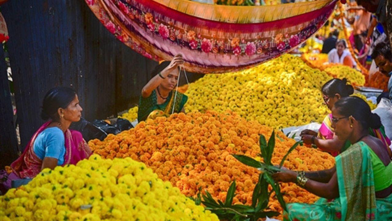 Enthusiastic shoppers carefully select vibrant flowers, particularly marigolds, to enhance the beauty of their rangoli designs. The fragrance of these flowers permeates the air.