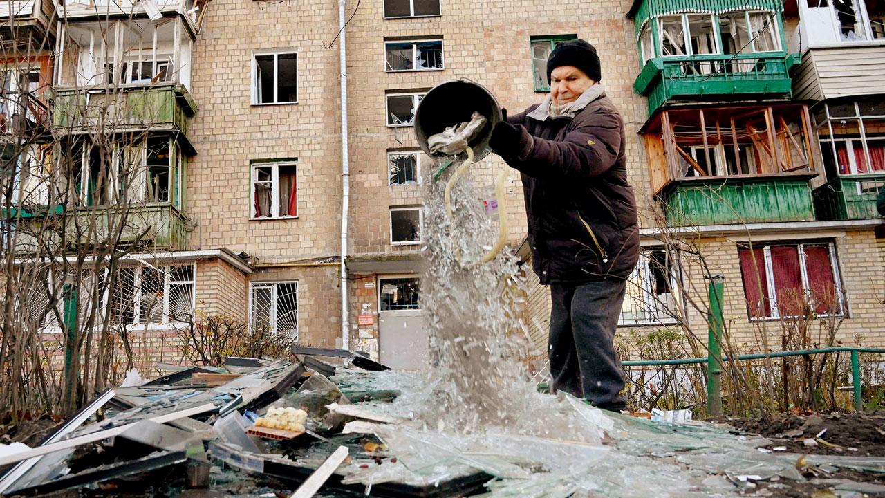 An inhabitant of an apartment sorts through broken glass after the drone attack on Kyiv’s residential buildings. PIC/AFP