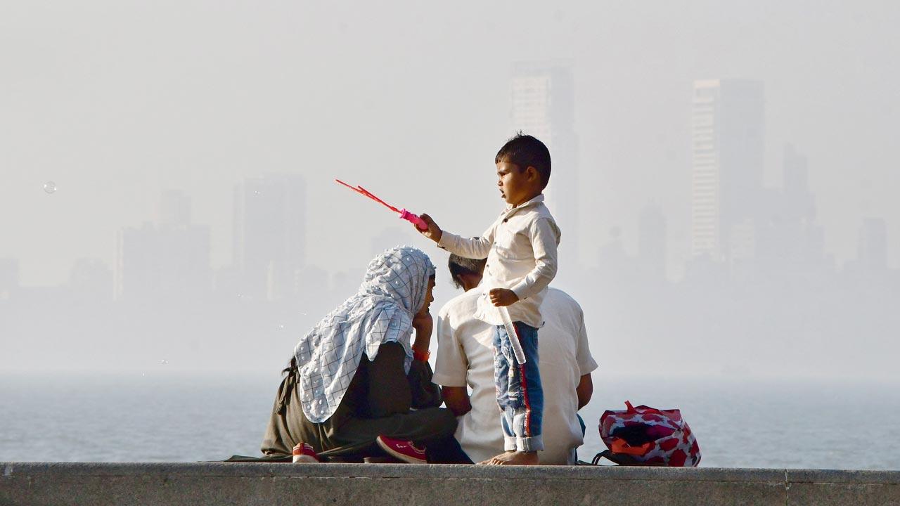 A child hawks balloon blowers at Marine Drive against a skyline shadowed by dense smog, earlier in January this year. Pic/Getty Images