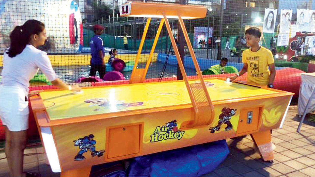 Kanak and Kavyansh play air hockey at an activity centre in Borivali