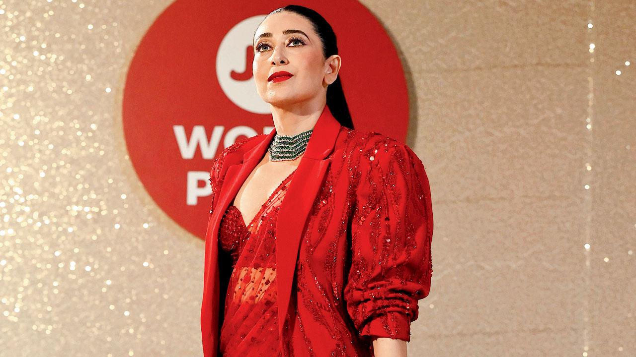 Karisma Kapoor sports an  embroidered jacket and a modern draped saree 