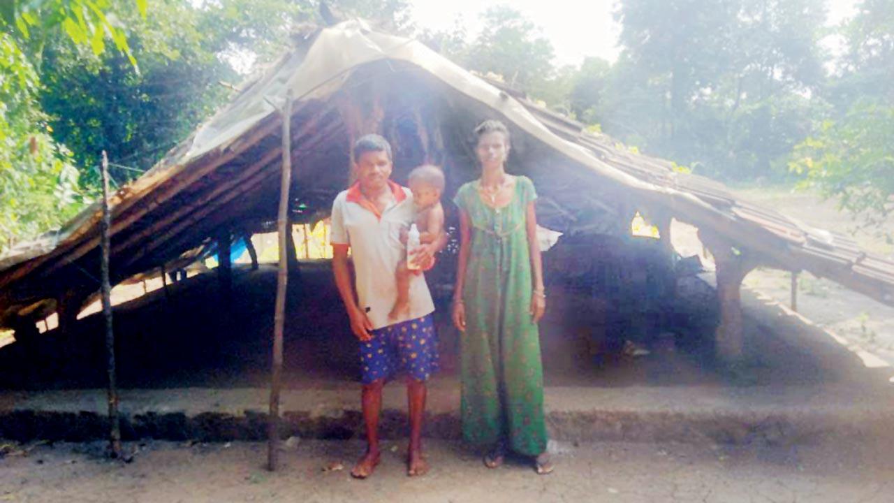 Deepak Damu Pawar with his wife and child near their hut