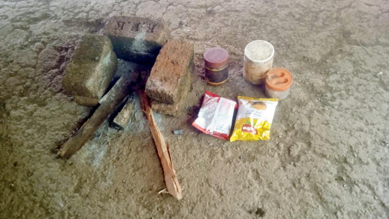 Snack packets next to a makeshift chulha inside Pawar’s hut