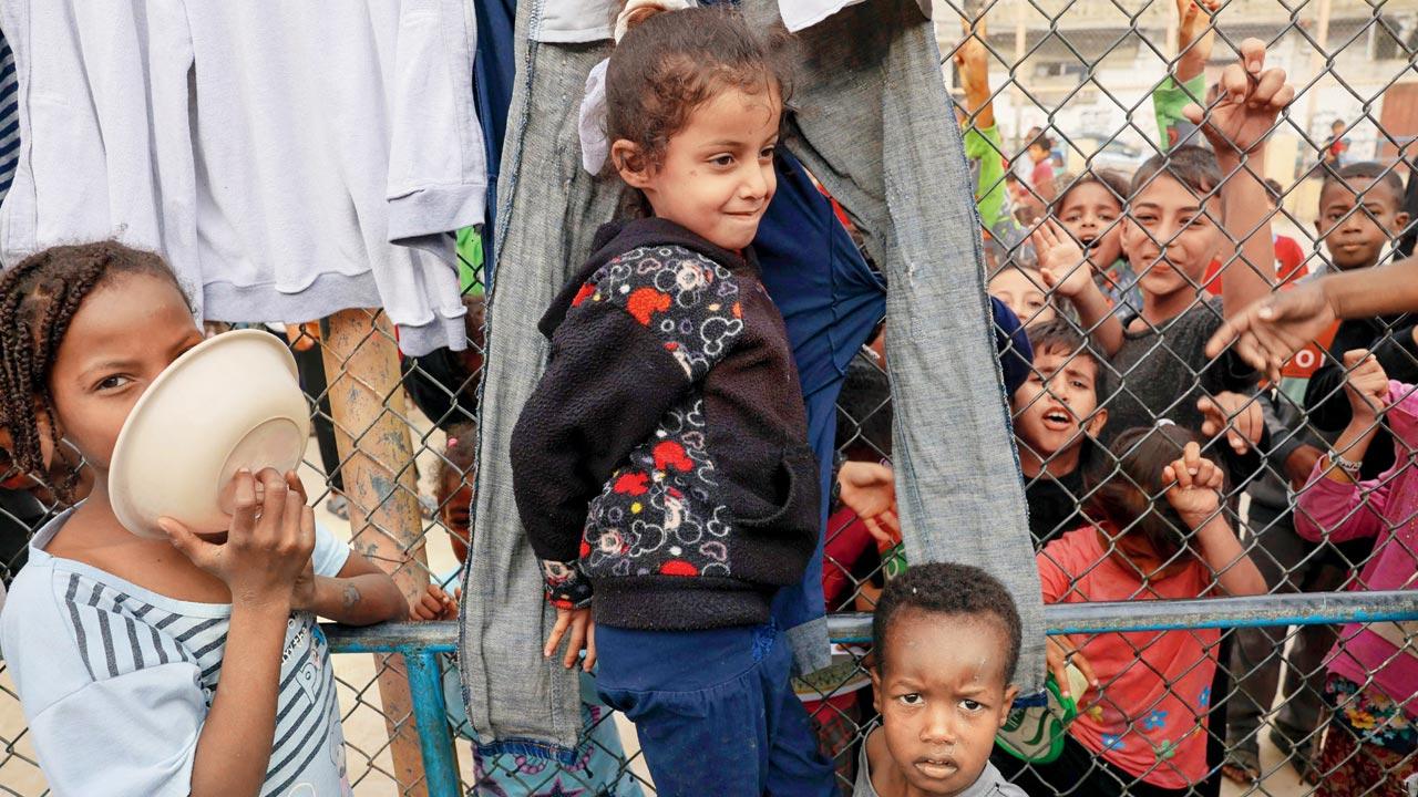 Displaced Palestinian kids wait for breakfast at a refugee camp in Rafah