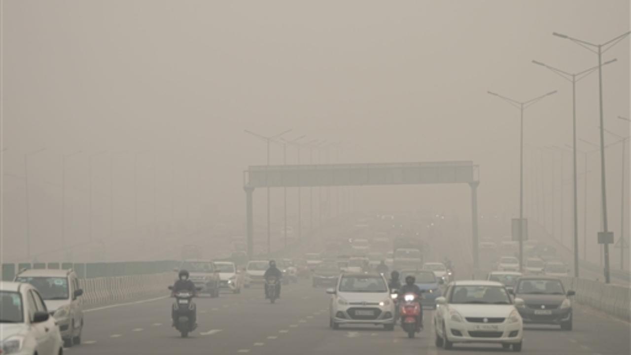 Commuters on a road shrouded in smog amid hazy weather conditions, in New Delhi (Pic/PTI)