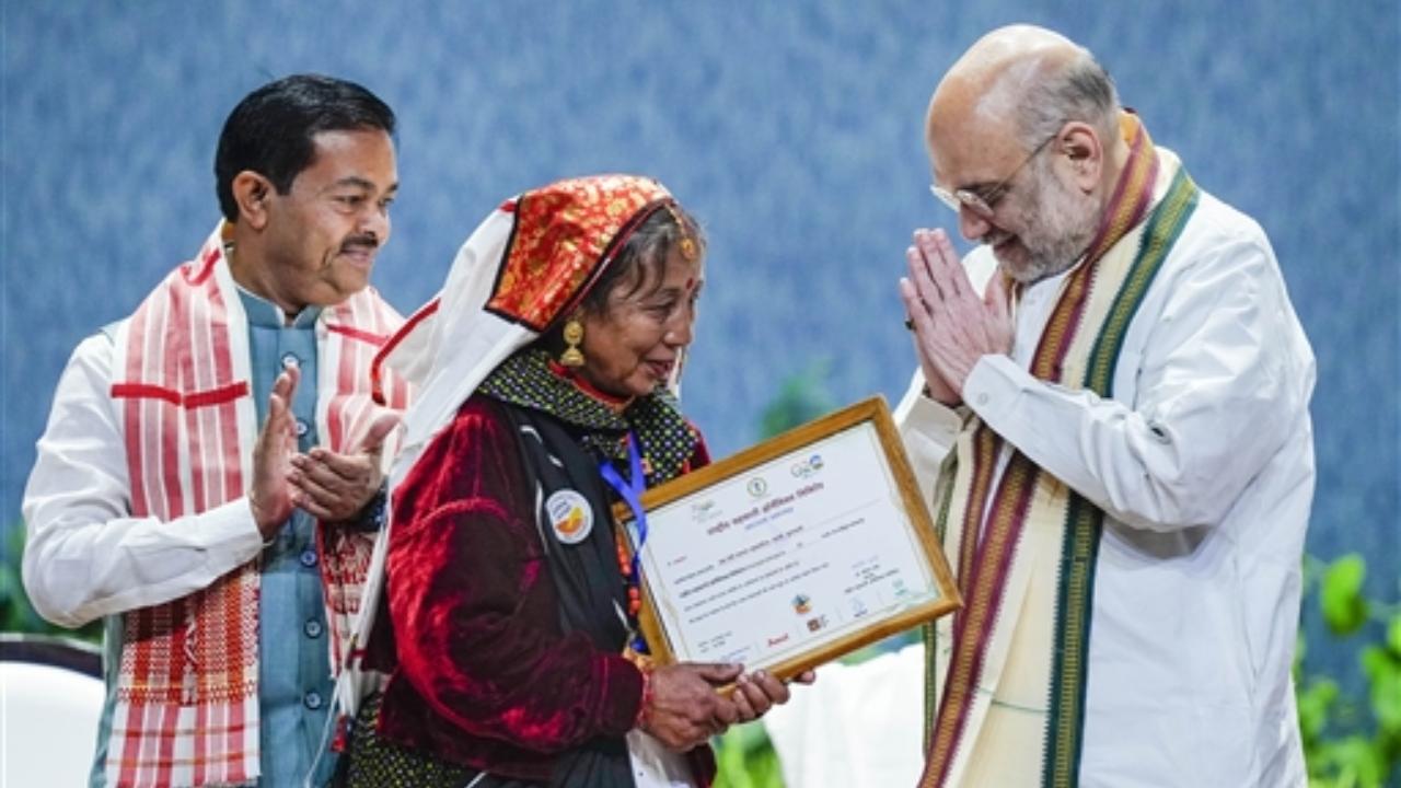 Union Home Minister and Minister of Cooperation Amit Shah distributes membership certificate to a National Cooperative Organics Limited (NCOL) member during the National Symposium on 'Promoting Organic Products through Cooperatives organised by NCOL, in New Delhi