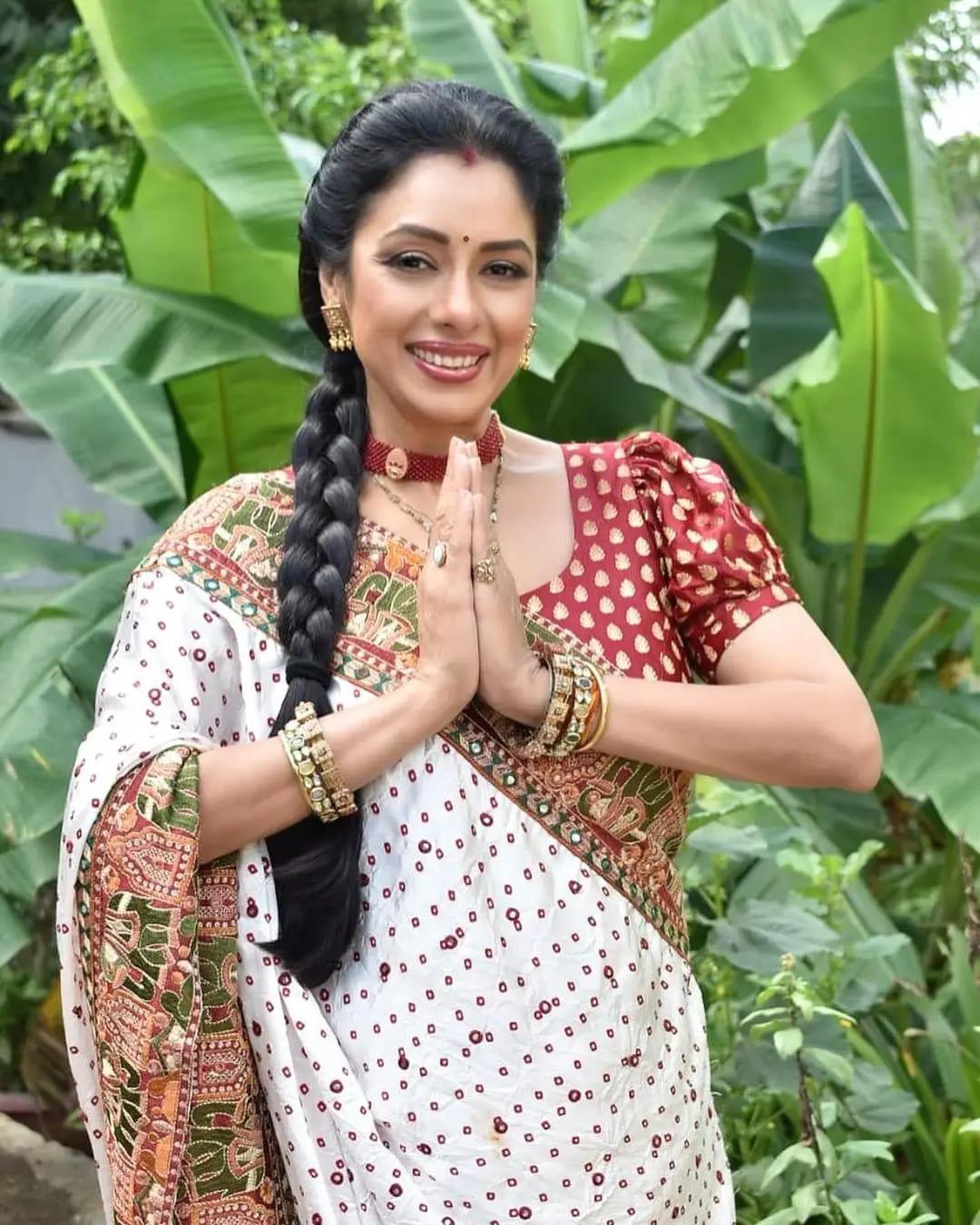 Rupali Ganguli radiates a captivating aura as she dons a stunning saree that effortlessly merges tradition with modern chic. The centerpiece of her outfit is a patterned blouse in a rich and vibrant crimson hue