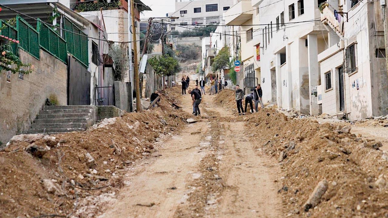 Locals clear a damaged road in the Jenin refugee camp, West Bank. Pics/AFP