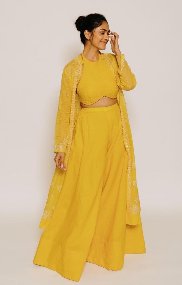Mrunal Thakur wore a bright yellow separates and matched it with a jacket. Her hair was done in a neat bun