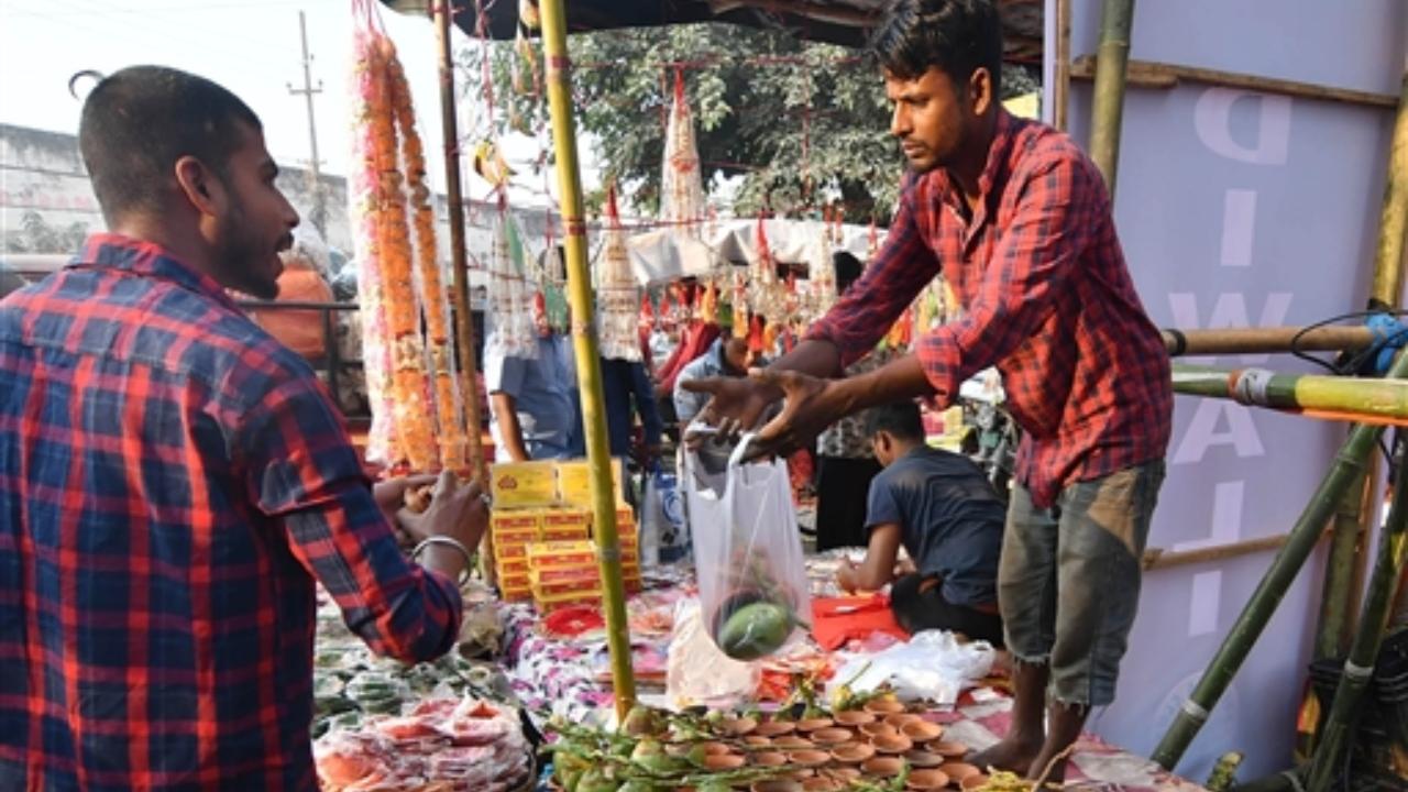 People purchase 'puja' items at a market for Diwali celebrations, in Guwahati