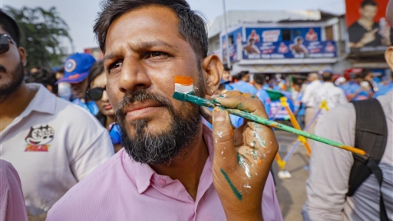 A fan gets his face painted in the colours of the national flag as he arrives at the Narendra Modi Stadium to watch the ICC Men’s Cricket World Cup 2023