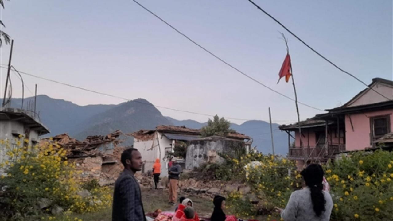Locals outside their houses after house their collapse following a strong earthquake (Pic/PTI)